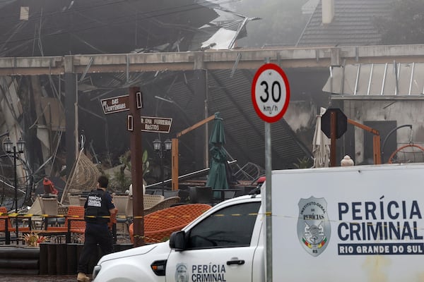 Police carry out an investigation outside houses that were hit by a plane in Gramado, Rio Grande do Sul state, Brazil, Sunday, Dec. 22, 2024. (AP Photo/Mateus Bruxel, Agência RBS)