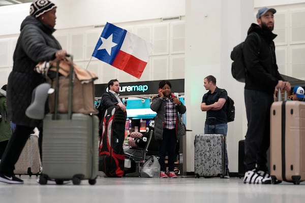 Passengers wait to check-in for their flights at George Bush Intercontinental Airport Monday, Jan. 20, 2025, in Houston, ahead of a winter storm that is expected to bring several inches of snow and will close both of Houston's airports on Tuesday. (AP Photo/David J. Phillip))