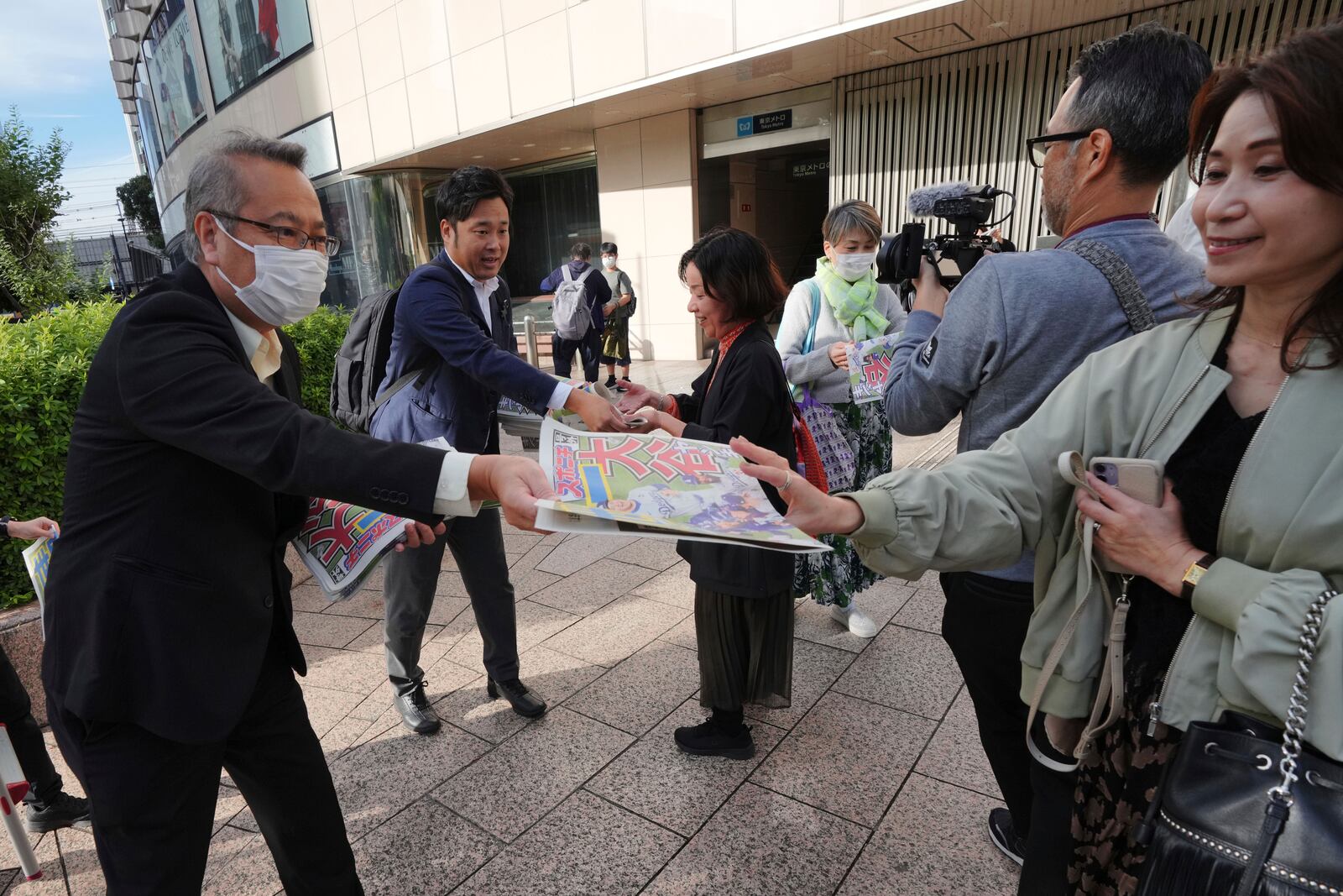 Staff members distribute copies of an extra edition of the Sports Nippon newspaper in Tokyo, Thursday, Oct. 31, 2024, reporting on the Los Angeles Dodgers' victory in the World Series baseball match after the Dodgers defeated the New York Yankees in Game 5 in New York. (AP Photo/Eugene Hoshiko)