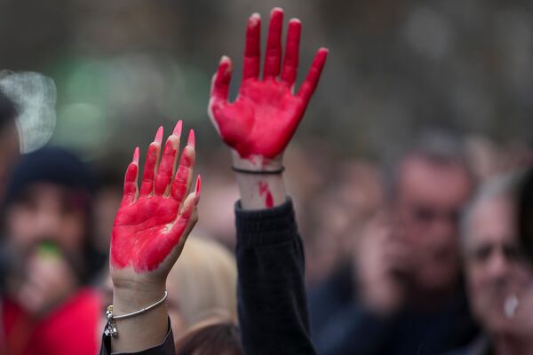 Women raise painted hands symbolising the blood during a protest, a day after the assault on students was carried out by thugs with baseball bats, in Novi Sad, Serbia, Tuesday, Jan. 28, 2025. (AP Photo/Darko Vojinovic)