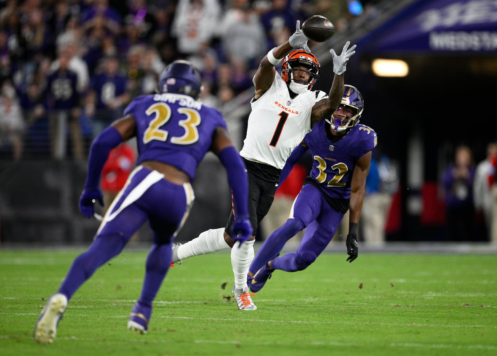 Cincinnati Bengals wide receiver Ja'Marr Chase (1) catches the ball as Baltimore Ravens linebacker Trenton Simpson (23) and safety Marcus Williams (32) move in during the first half of an NFL football game, Thursday, Nov. 7, 2024, in Baltimore. (AP Photo/Nick Wass)