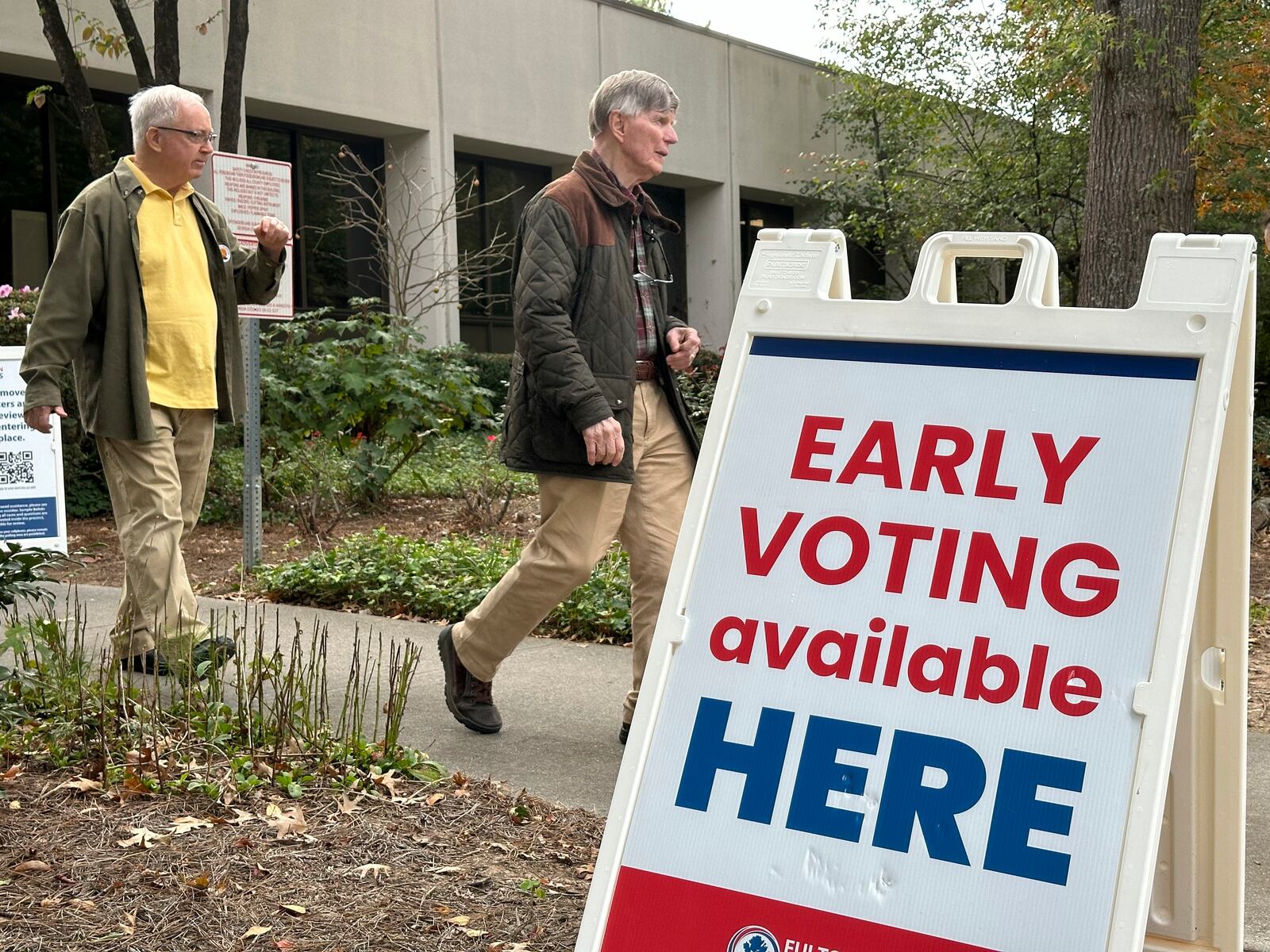 People leave after voting in the Atlanta suburb of Sandy Springs, Ga., on Tuesday, Oct. 15, 2024, the first day of early in-person voting in Georgia. (AP Photo/Jeff Amy)