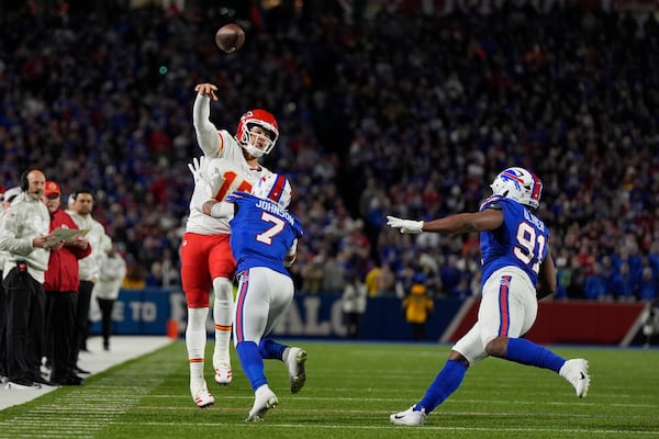 Kansas City Chiefs quarterback Patrick Mahomes (15) throws over Buffalo Bills cornerback Taron Johnson (7) and defensive tackle Ed Oliver (91) during the first half of an NFL football game Sunday, Nov. 17, 2024, in Orchard Park, N.Y. (AP Photo/Julia Demaree Nikhinson)