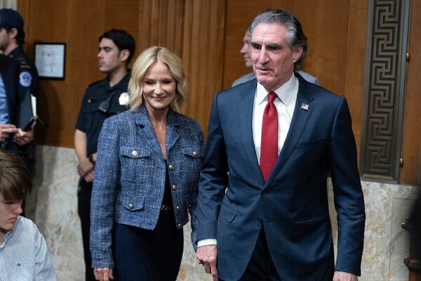 Former Gov. Doug Burgum, President-elect Donald Trump's choice to lead the the Interior Department as Secretary of the Interior, right, arrives with his wife Kathryn Burgum to testify before the Senate Energy and Natural Resources Committee on Capitol Hill in Washington, Thursday, Jan. 16, 2025. (AP Photo/Jose Luis Magana)