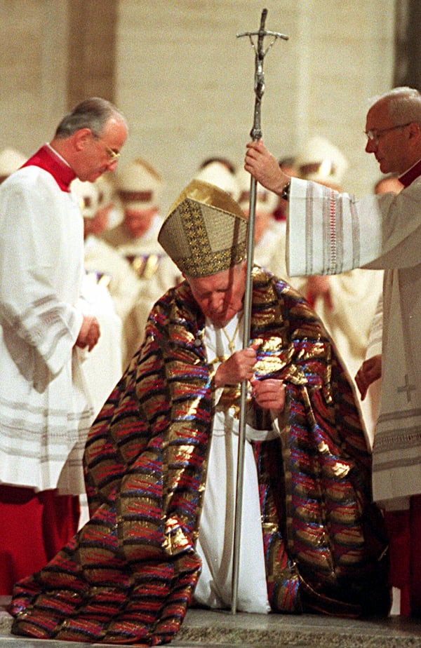 FILE - Pope John Paul II walks through the bronze Holy Door of St. Peter's Basilica at the Vatican, late Friday night, Dec. 24, 1999. (AP Photo/Andrew Medichini, File)