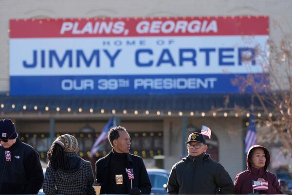 People wait for a funeral procession for former President Jimmy Carter to move through downtown Plains, Ga., Saturday, Jan. 4, 2025. (AP Photo/)