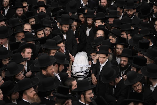 Ultra-Orthodox Jewish mourners gather for the funeral of Yehoshua Aharon Tuvia Simcha, 12, fatally shot by a gunman who opened fire on a bus, in Jerusalem, Thursday, Dec. 12, 2024. (AP Photo/Mahmoud Illean)