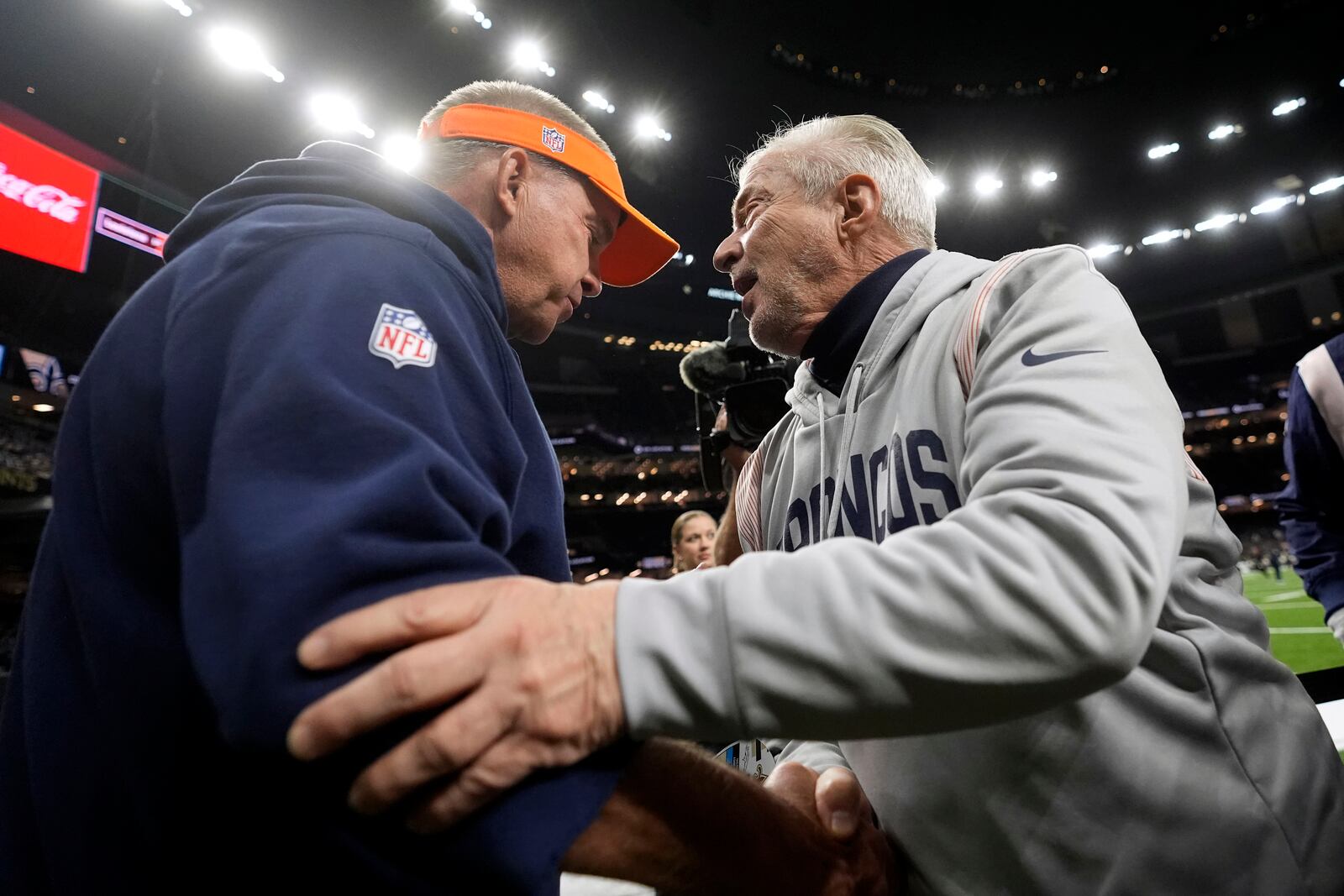 Denver Broncos head coach Sean Payton, left, greets his brother Tom Payton as he walks onto the field before an NFL football game against the New Orleans Saints, Thursday, Oct. 17, 2024, in New Orleans. (AP Photo/Gerald Herbert)