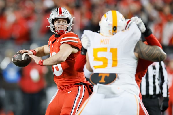 Ohio State quarterback Will Howard, left, drops back to pass against Tennessee during the first half in the first round of the College Football Playoff, Saturday, Dec. 21, 2024, in Columbus, Ohio. (AP Photo/Jay LaPrete)