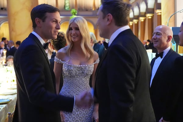 Elon Musk shakes hands with Jared Kushner as Ivanka Trump and Jeff Bezos watch, before President-elect Donald Trump speaks at a dinner at the Building Museum, Sunday, Jan. 19, 2025, in Washington. (AP Photo/Evan Vucci)