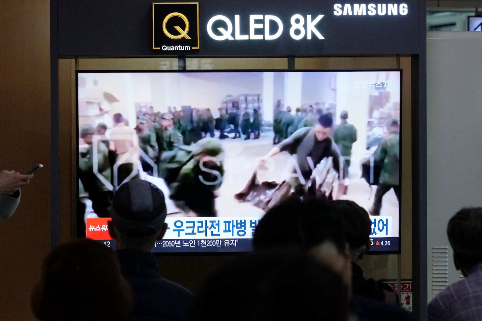 A TV screen shows an image of soldiers believed to be from North Korea stand in line to receive supplies from Russia during a news program at Seoul Railway Station in Seoul, South Korea, Monday, Oct. 21, 2024. (AP Photo/Ahn Young-joon)