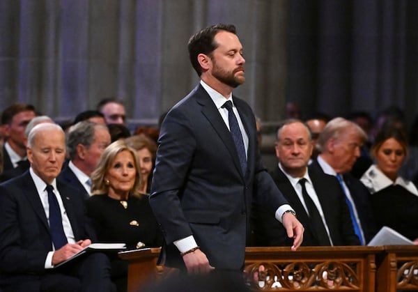 Jason Carter walks to speak during the state funeral for his grandfather former President Jimmy Carter at the National Cathedral, Thursday, Jan. 9, 2025, in Washington. Looking on from left are President Joe Biden, first lady Jill Biden, second gentleman Doug Emhoff, President-elect Donald Trump and his wife Melania Trump. (Ricky Carioti/The Washington Post via AP, Pool)