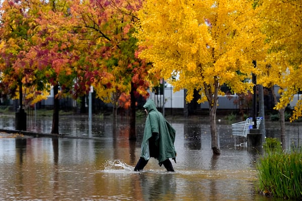 A pedestrian walks along a flooded street during a storm Thursday, Nov. 21, 2024, in Santa Rosa, Calif. (AP Photo/Jeff Chiu)