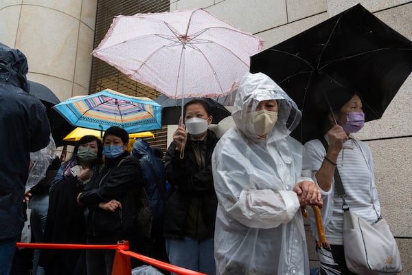 People wait outside the West Kowloon Magistrates' Courts in Hong Kong Tuesday, Nov. 19, 2024, ahead of the sentencing in national security case. (AP Photo/Chan Long Hei)