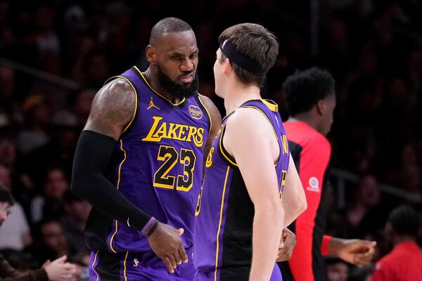 Los Angeles Lakers forward LeBron James, left, celebrates with guard Austin Reaves after making his 30th point of the game during the second half of an NBA basketball game against the Atlanta Hawks, Friday, Jan. 3, 2025, in Los Angeles. With that shot, James surpassed Michael Jordon for most 30-point regular season games in NBA history. (AP Photo/Mark J. Terrill)