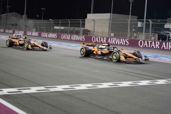 McLaren driver Oscar Piastri of Australia crosses the finish line followed by his teammate McLaren driver Lando Norris of Britain during sprint race at the Formula One Qatar Grand Prix, at the Lusail International Circuit in Lusail, Qatar, Saturday, Nov. 30, 2024. (AP Photo/Pool/ Altaf Qadri)