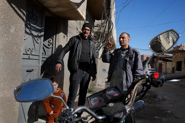 Hussein Arbeeni, 41, right, speaks with his brother Hassan Arbeeni, 42, right, outside their house at an alley that was hit by the sarin struck during a 2013 chemical weapons attack that was blamed on then President Bashar Assad's forces, in Zamalka neighbourhood, on the outskirts of Damascus, Syria, Wednesday, Dec. 25, 2024. (AP Photo/Hussein Malla)