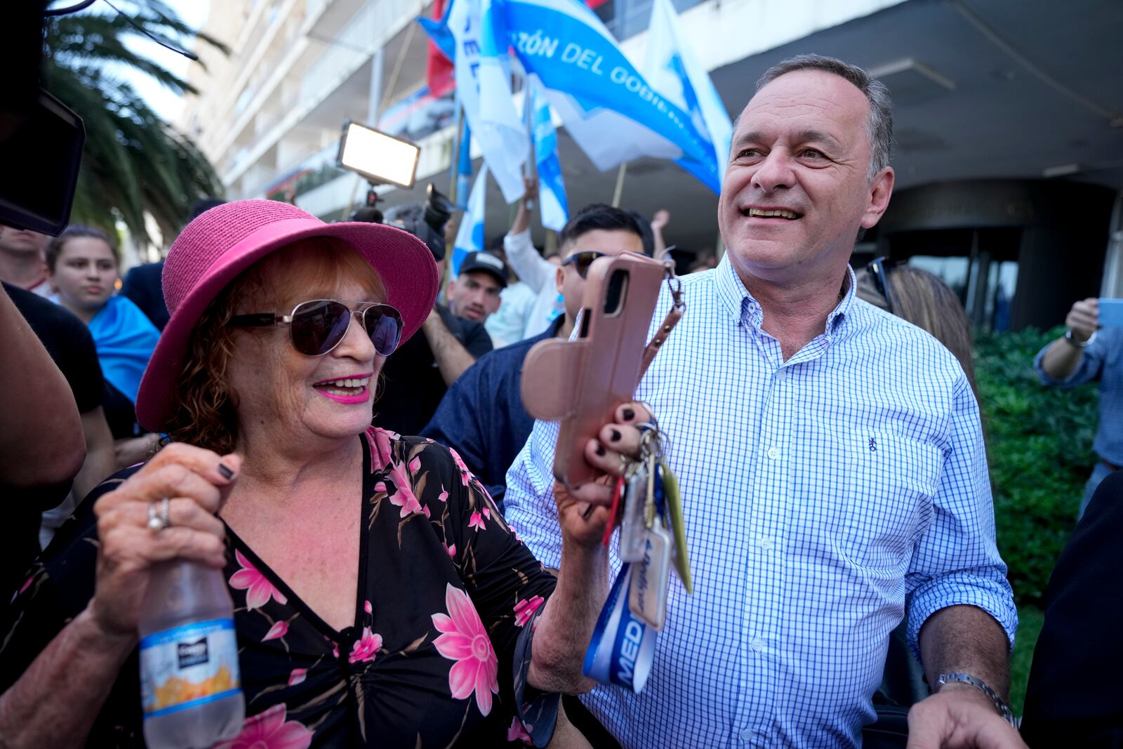 Alvaro Delgado, presidential candidate for the ruling National Party, walks alongside a supporter outside a polling station during general elections in Montevideo, Uruguay, Sunday, Oct. 27, 2024. (AP Photo/Natacha Pisarenko)