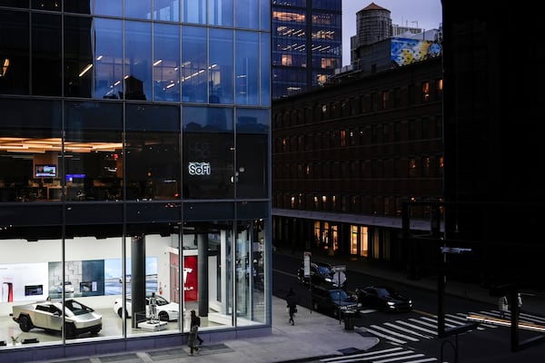 People walk past a Tesla store in the Meatpacking District of Manhattan, Friday, Nov. 22, 2024, in New York. (AP Photo/Julia Demaree Nikhinson)