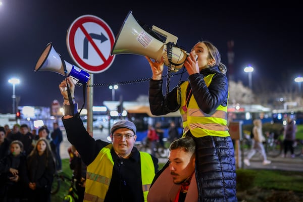 A woman speaks on a speaker indicating gathering places for students protesting over the collapse of a concrete canopy that killed 15 people more than two months ago, in Novi Sad, Serbia, Friday, Jan. 31, 2025. (AP Photo/Armin Durgut)