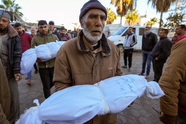 Abdallah Abu Libda carries the body of his 6-month-old nephew, Mohammad Abu Libda, as victims of overnight Israeli army strikes at multiple locations in the central Gaza Strip are prepared for funeral prayers at Al-Aqsa Martyrs Hospital in Deir al-Balah, on Friday, Jan. 3, 2025. According to Al-Aqsa Martyrs Hospital, 30 people, including 10 women and 7 children, were killed in the attacks. (AP Photo/Abdel Kareem Hana)