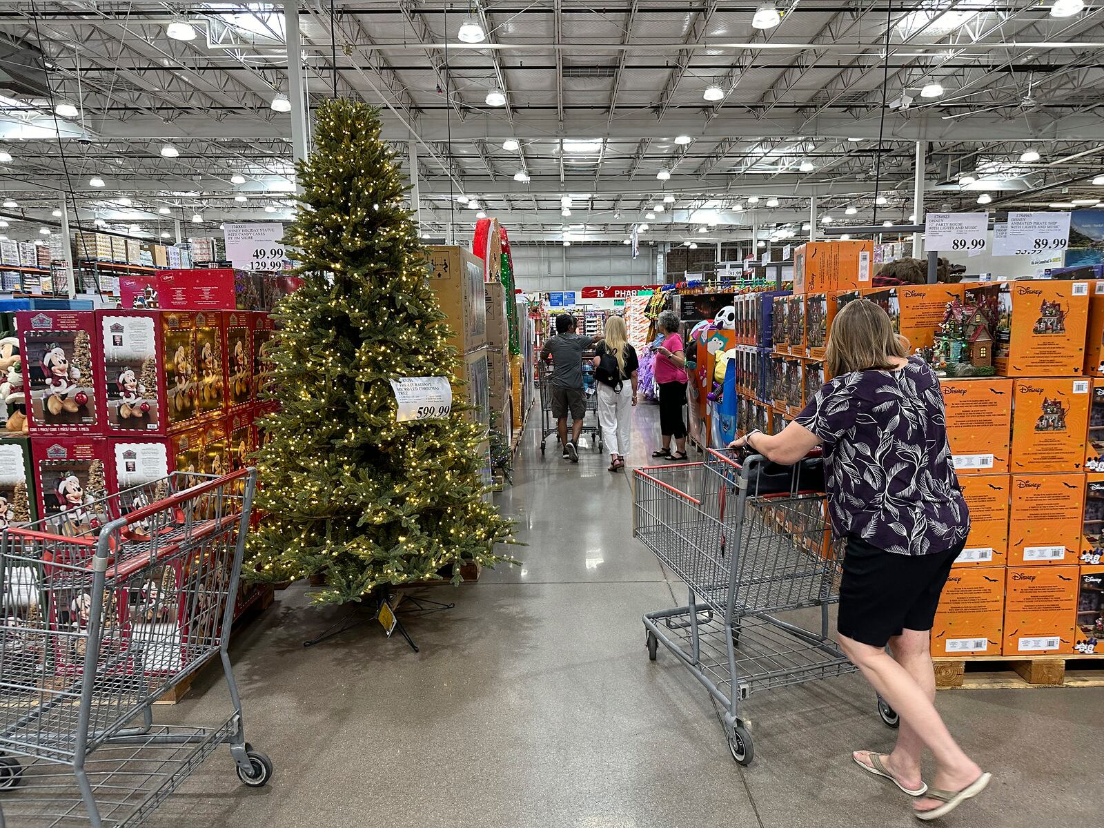 FILE - A shopper passes by a Christmas tree on display in a Costco warehouse on Sept. 12, 2024, in Thornton, Colo. (AP Photo/David Zalubowski, File)