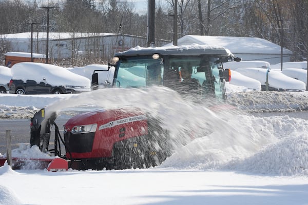 A man clears a path through the snow using a tractor in Elma, N.Y., Monday, Dec. 2, 2024. (AP Photo/Gene J. Puskar)