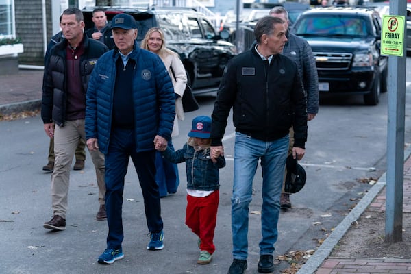 President Joe Biden, from front left, accompanied by his grandson Beau, son Hunter Biden, and daughter-in-law Melissa Cohen Biden, background center, walk in downtown Nantucket, Mass., Friday, Nov. 29, 2024. (AP Photo/Jose Luis Magana)