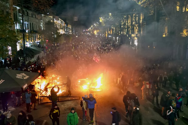 Protesters pour into the streets and put fire following Georgian Prime Minister Irakli Kobakhidze's announcement, rallying outside the parliament building in Tbilisi, Georgia, on Friday, Nov. 29, 2024. (AP Photo/Zurab Tsertsvadze)