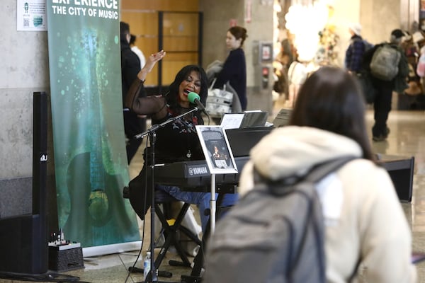 Roz McCommen performs amid travelers at Seattle-Tacoma International Airport on November 26, 2024, in SeaTac, Wash. (AP Photo/Manual Valdes)