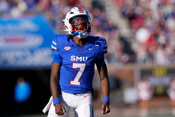 SMU quarterback Kevin Jennings (7) reacts to showing a touchdown pass to teammate wide receiver Derrick McFall (20) during the first half of an NCAA college football game against California, Saturday, Nov. 30, 2024, in Dallas. (AP Photo/LM Otero)