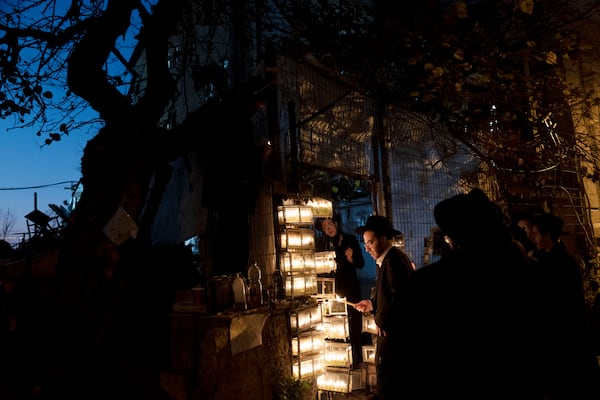 Ultra-Orthodox Jewish yeshiva students light candles to mark the holiday of Hanukkah in Jerusalem, Wednesday, Jan. 1, 2025. (AP Photo/Maya Alleruzzo)