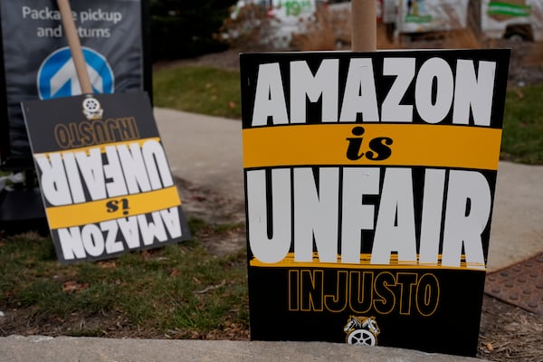 Signs are seen during a strike at Skokie (DIL7) Amazon Delivery station in Skokie, Ill., Thursday, Dec. 19, 2024. (AP Photo/Nam Y. Huh)