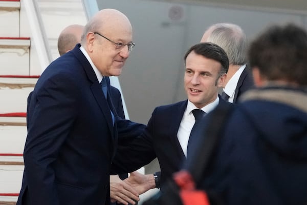 Lebanese caretaker Prime Minister Najib Mikati, left, welcomes French President Emmanuel Macron upon his arrival at Beirut's Rafic Hariri International Airport in Beirut, Lebanon, Friday, Jan. 17, 2025. (AP Photo/Hassan Ammar)