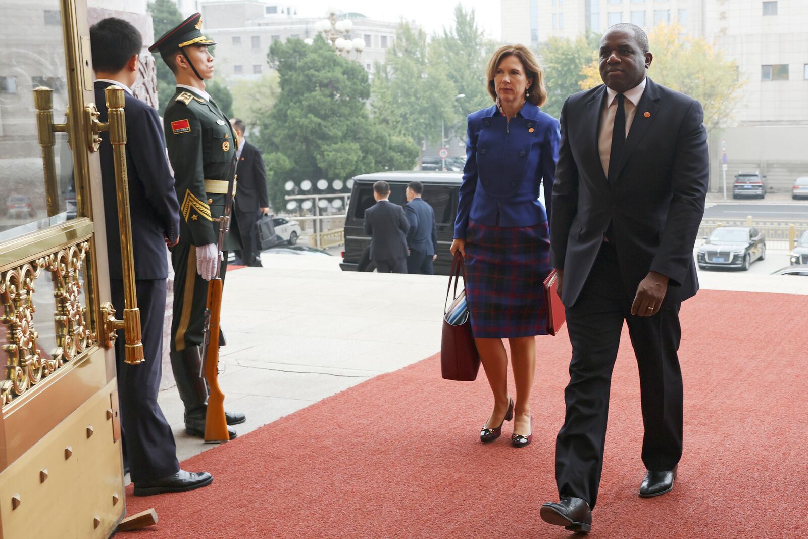 Britain's Foreign Secretary David Lammy, right, and British Ambassador to China Caroline Wilson arrive to the Great Hall of the People in Beijing Friday, Oct. 18, 2024. (Florence Lo/Pool Photo via AP)