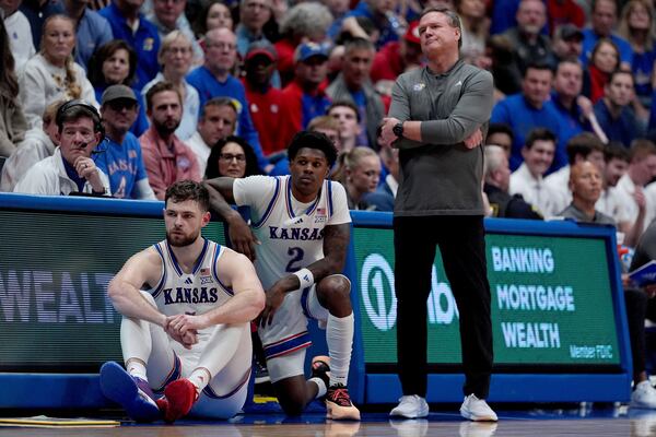 Kansas head coach Bill Self watches with center Hunter Dickinson, left, and guard AJ Storr (2) during the second half of an NCAA college basketball game against UNC Wilmington, Tuesday, Nov. 19, 2024, in Lawrence, Kan. (AP Photo/Charlie Riedel)