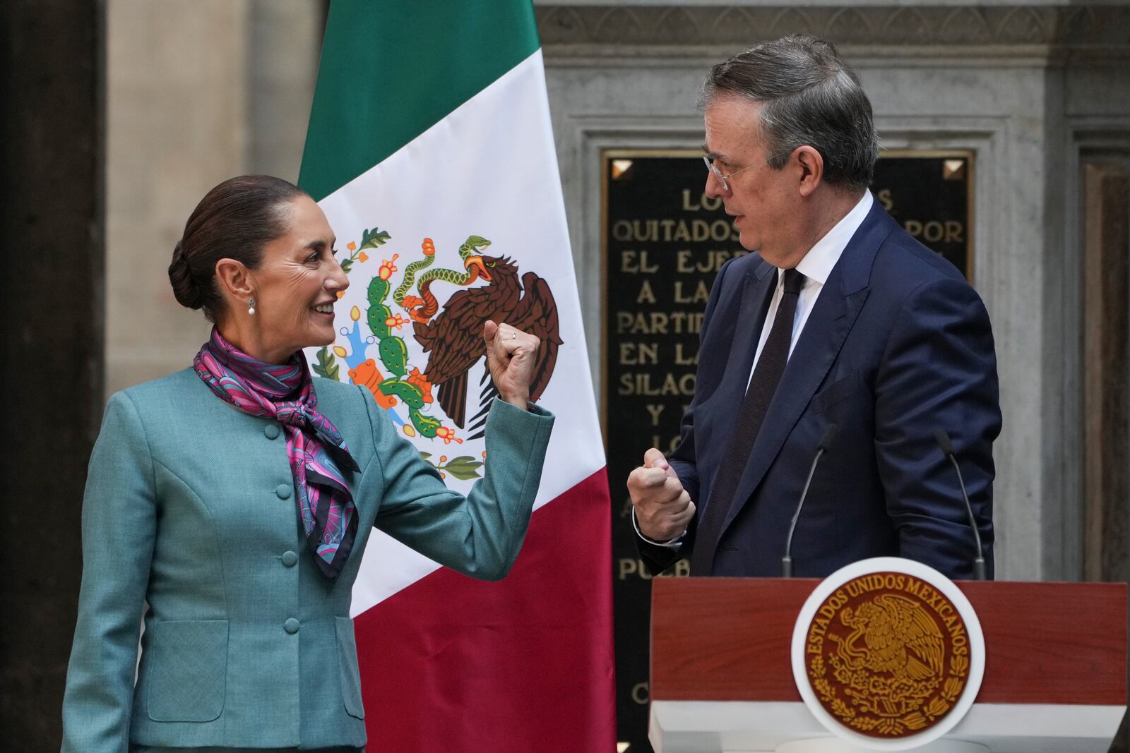 Mexican President Claudia Sheinbaum, left, speaks with her Economy Secretary Marcelo Ebrard during a news conference at the National Palace in Mexico City, Tuesday, Oct. 15, 2024. (AP Photo/Fernando Llano)