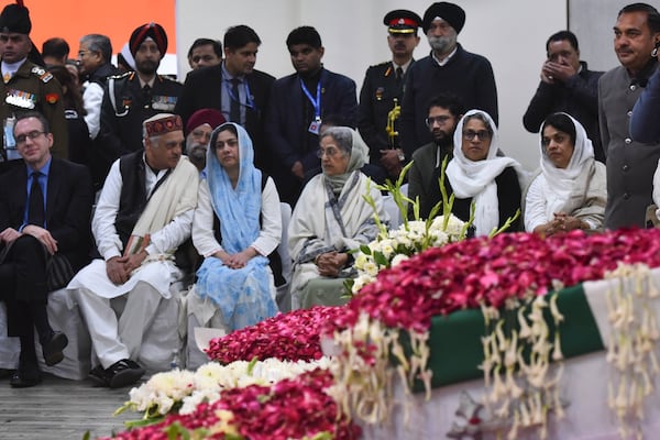 Gursharan Kaur, center right, wife of former Indian Prime Minister Manmohan Singh, sits with others next to the casket of her late husband at Congress party headquarters in New Delhi, India, Saturday, Dec. 28, 2024. (AP Photo)