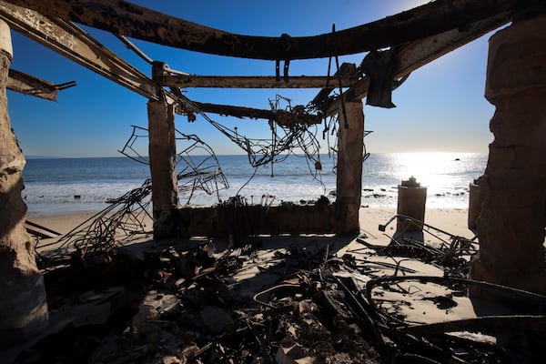 The Pacific Ocean is seen through a fire-ravaged property in the aftermath of the Palisades Fire Tuesday, Jan. 14, 2025 in Malibu, Calif. (AP Photo/Ethan Swope)