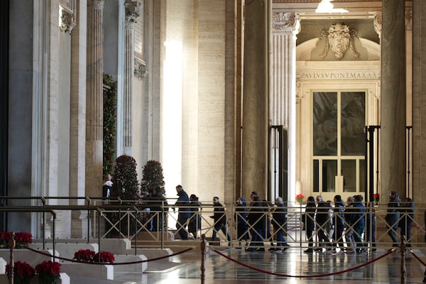 Faithful arrive to walk through the Holy Door of St.Peter's Basilica at the Vatican, Wednesday, Dec. 25, 2024, after it was opened by Pope Francis on Christmas Eve marking the start of the Catholic 2025 Jubilee. (AP Photo/Andrew Medichini)