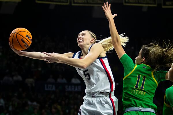 UConn guard Paige Bueckers (5) drives past Notre Dame guard Sonia Citron (11) during the first half of an NCAA college basketball game Thursday, Dec. 12, 2024, in South Bend, Ind. (AP Photo/Michael Caterina)