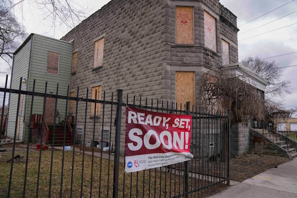 A sign reads "Ready, Set, Soon!" on a boarded-up property set for demolition to make room for a new train station where the Chicago Transit Authority plans to expand the Red Line train route on West 111th Street, Wednesday, Dec. 11, 2024, in the Roseland neighborhood of Chicago. (AP Photo/Erin Hooley)