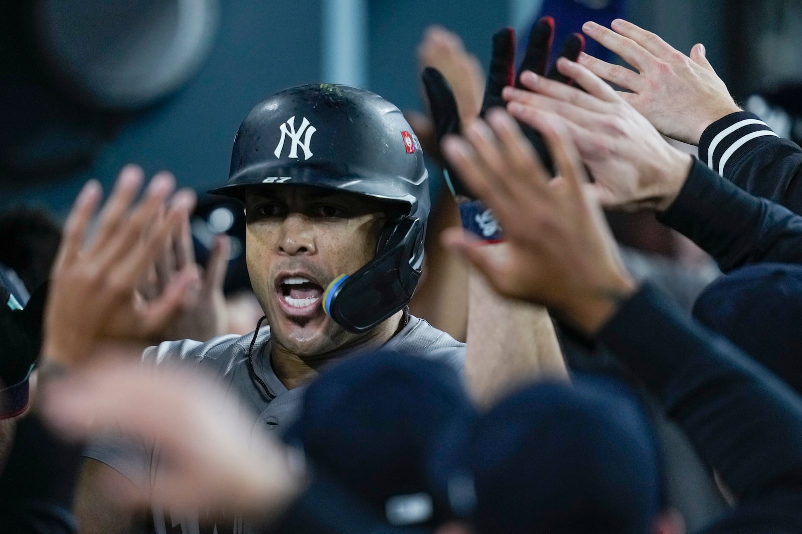 New York Yankees' Giancarlo Stanton celebrates in the dugout after his two-run home run against the Los Angeles Dodgers during the sixth inning in Game 1 of the baseball World Series, Friday, Oct. 25, 2024, in Los Angeles.(AP Photo/Ashley Landis)