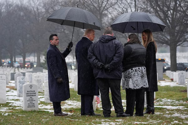 President-elect Donald Trump and Melina Trump talks with family members in Section 60 at Arlington National Cemetery, Sunday, Jan. 19, 2025, in Arlington, Va. (AP Photo/Evan Vucci)