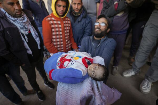 EDS NOTE: GRAPHIC CONTENT - Yehia al-Batran grieves as he holds the body of his 20-day-old son Jomaa, who died from hypothermia, at Al-Aqsa Martyrs Hospital in central Gaza, Sunday, Dec. 29, 2024. Jomaa's twin brother, Ali, remains in intensive care, as local health officials report at least three other infant deaths from the cold in recent weeks. (AP Photo/Abdel Kareem Hana)