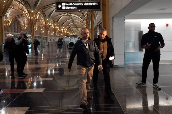 Rob Henning, center, walks to check on passengers at Ronald Reagan Washington National Airport, Thursday, Jan. 30, 2025, in Arlington, Va. (AP Photo/Julio Cortez)