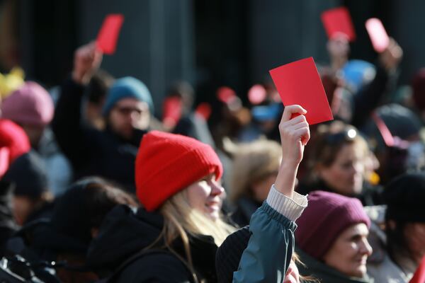 Demonstrators hold red cards outside of the Georgian parliament where the President-elect Mikheil Kavelashvili, a former soccer player, takes his oath at the swearing-in ceremony, in Tbilisi, Georgia, Sunday, Dec. 29, 2024. (AP Photo/Zurab Tsertsvadze)