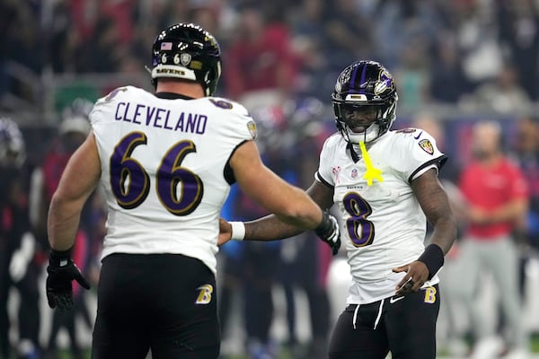 Baltimore Ravens quarterback Lamar Jackson (8) celebrates with teammate Ben Cleveland (66) after throwing a touchdown pass during the second half of an NFL football game against the Houston Texans, Wednesday, Dec. 25, 2024, in Houston. (AP Photo/David J. Phillip)