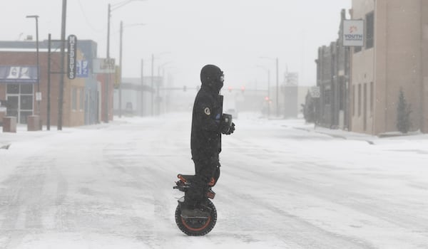 Brenden Campbell makes his way through downtown Wichita, Kan., on a one-wheel electric scooter during a severe winter storm on Sunday, Jan. 5, 2024 (Travis Heying/The Wichita Eagle via AP)