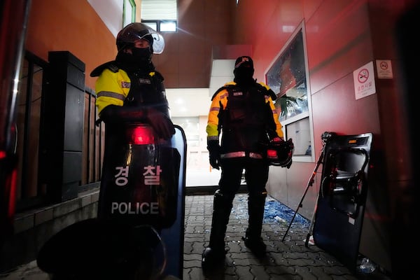 Police officers stand at the Seoul Western District Court after supporters of impeached South Korean President Yoon Suk Yeol broke into the court in Seoul, South Korea, Sunday, Jan. 19, 2025. (AP Photo/Ahn Young-joon)